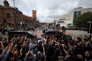 Sharon Osbourne y su familia (C) miran los tributos en el banco y el puente de los fans de Black Sabbath mientras el cortejo fúnebre del músico Ozzy Osbourne pasa por Birmingham, Reino Unido, el 30 de julio de 2025. Osbourne falleció a los 76 años el 22 de julio de 2025, semanas después de su último concierto con Black Sabbath. Le habían diagnosticado la enfermedad de Parkinson en 2019. (Reino Unido) EFE/EPA/ADAM VAUGHAN