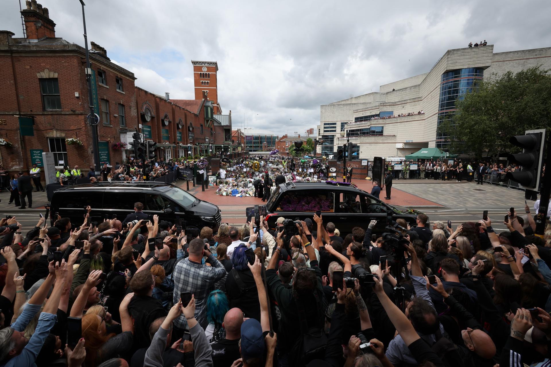 Sharon Osbourne y su familia (C) miran los tributos en el banco y el puente de los fans de Black Sabbath mientras el cortejo fúnebre del músico Ozzy Osbourne pasa por Birmingham, Reino Unido, el 30 de julio de 2025. Osbourne falleció a los 76 años el 22 de julio de 2025, semanas después de su último concierto con Black Sabbath. Le habían diagnosticado la enfermedad de Parkinson en 2019. (Reino Unido) EFE/EPA/ADAM VAUGHAN