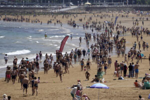 Cientos de personas se disfrutan este sábado, de las altas temperaturas, en la playa de San Lorenzo de Gijón. EFE/Paco Paredes