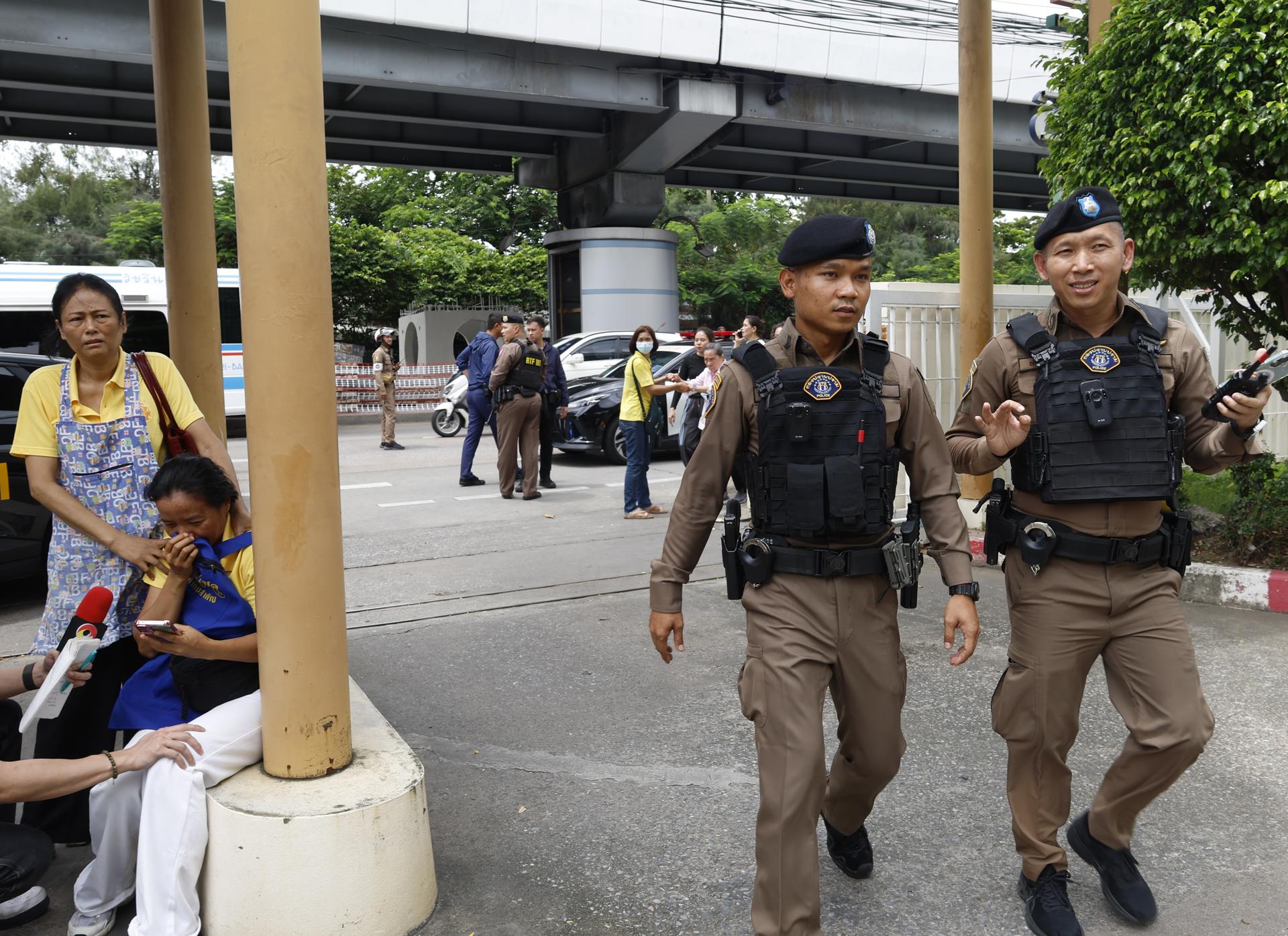 Dos miembros de la Policía de Tailandia en el lugar del tiroteo registrado este lunes en Bangkok.
EFE/EPA/NARONG SANGNAK
