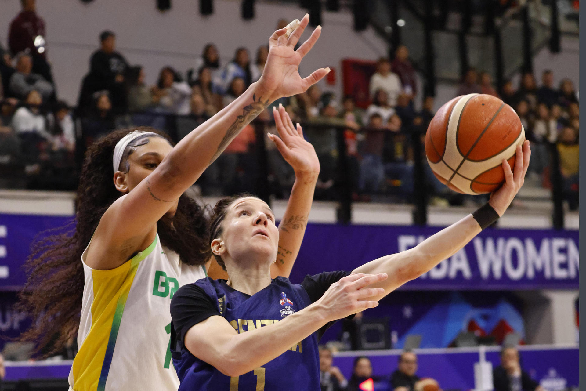 La pivot brasileña Kamilla Cardoso (i) bloquea el ataque de la base argentina Melisa Gretter este sábado en Santiago de Chile durante el partido de las semifinales que ha clasificado al quinteto verdeamarillo al juego por el título contra Estados Unidos. EFE/ Marcelo Hernandez / Instituto Nacional de Deportes / SOLO DISPONIBLE PARA ILUSTRAR LA NOTICIA QUE ACOMPAÑA (CRÉDITO OBLIGATORIO)