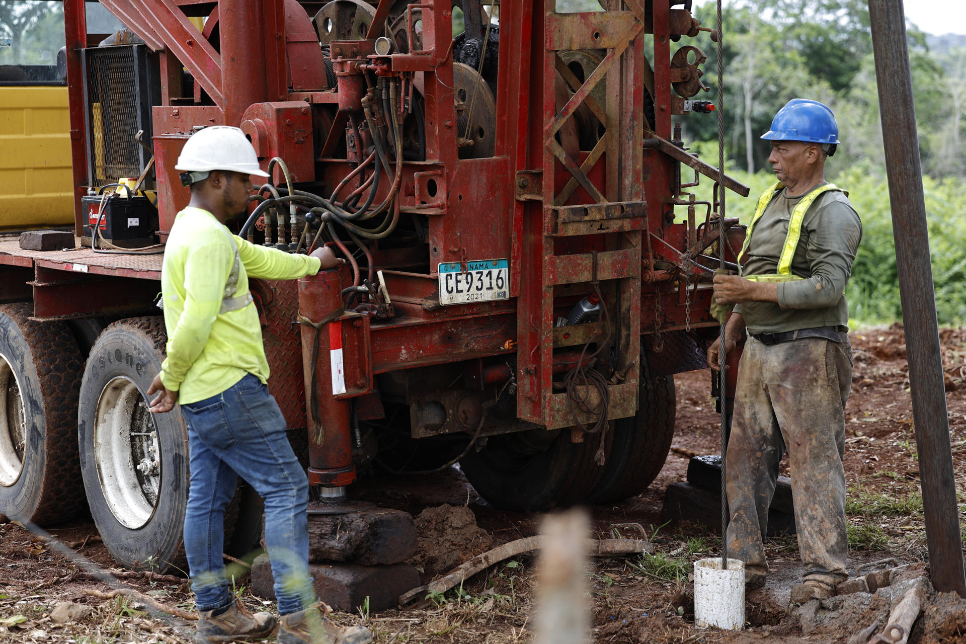 Trabajadores observan una máquina perforadora este miércoles, en el corregimiento Potrero Grande, en La Chorrera (Panamá). EFE/ Bienvenido Velasco