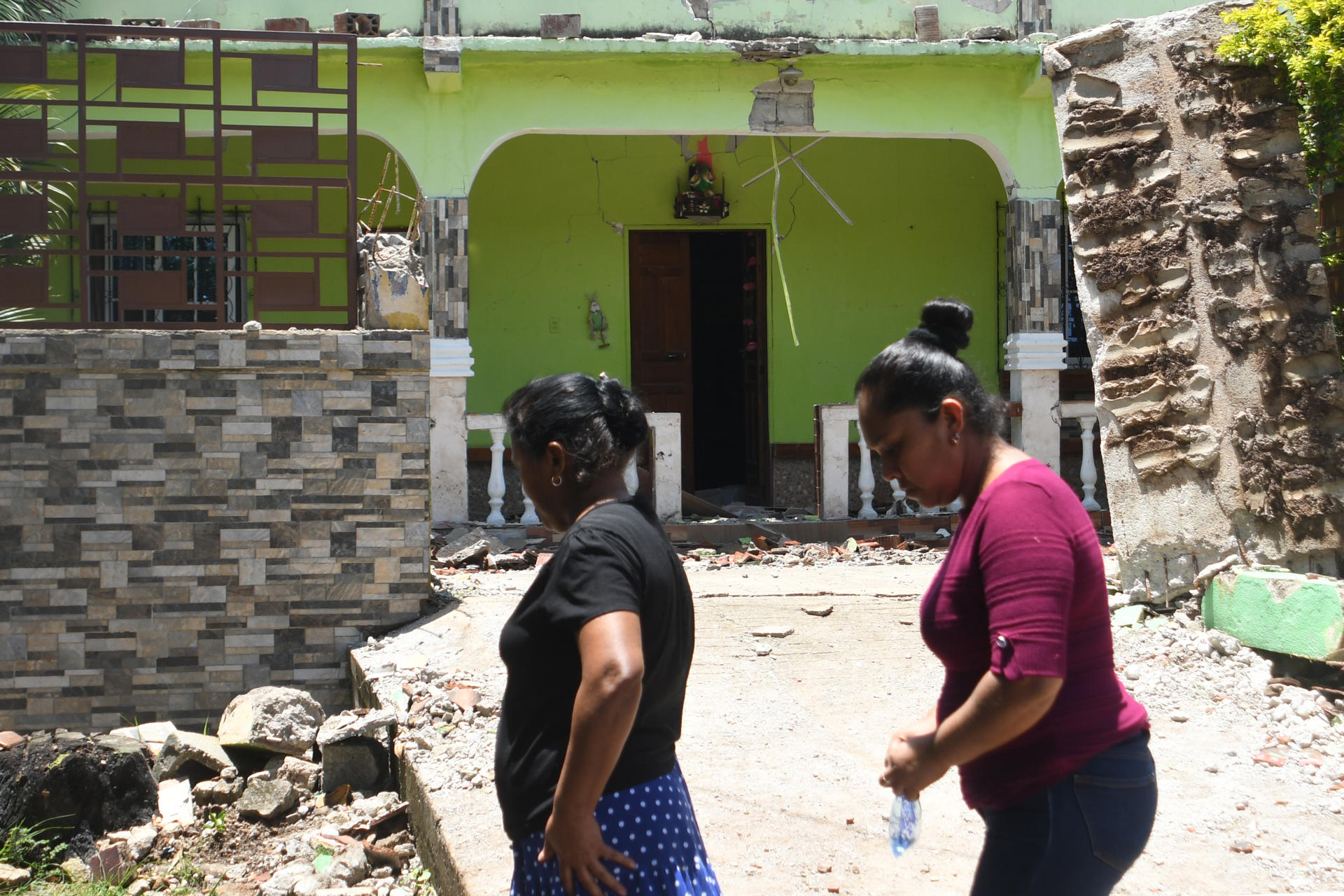 Mujeres caminan frente a una vivienda afectada por un sismo este miércoles, en el caserio San Miguel Comapa, Jutiapa (Guatemala). EFE/ Alex Cruz
