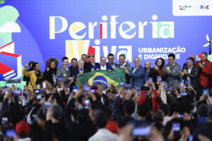 El presidente de Brasil, Luíz Inácio Lula da Silva (c-i), sostiene la bandera de Brasil junto al vicepresidente de Brasil, Geraldo Alckmin (c-d), durante el lanzamiento del Plan de Urbanización de Favelas este viernes, en Osasco (Brasil). EFE/ Isaac Fontana