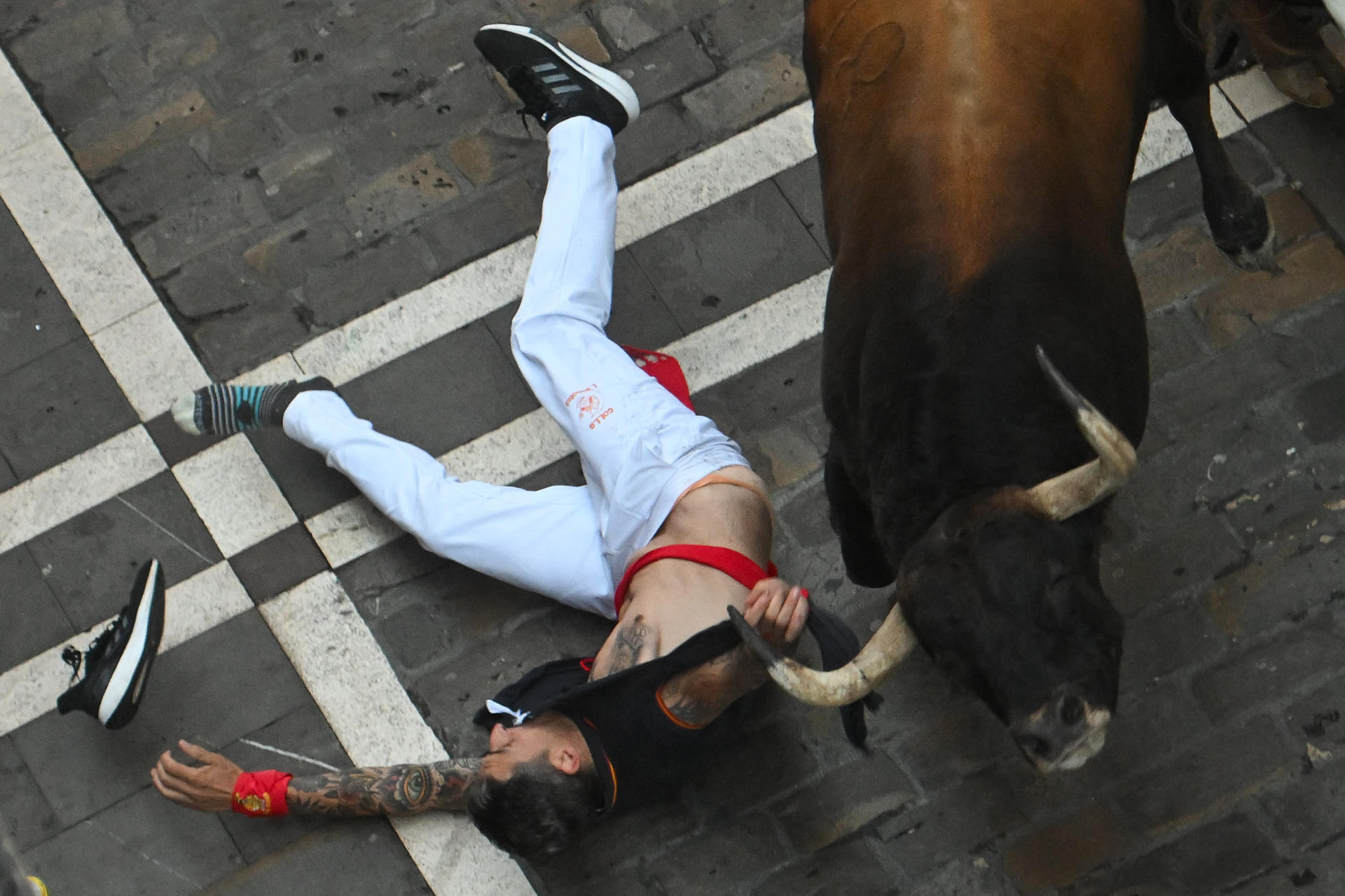 Un mozo es corneado por uno de los toros de la ganadería Álvaro Núñez durante el tercer encierro de los Sanfermines 2025 este miércoles en Pamplona. EFE/ Jose Luis Larrión