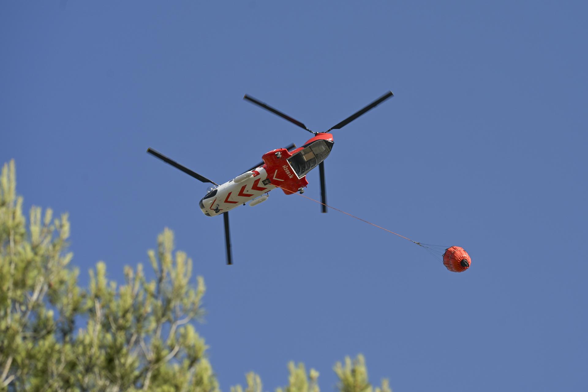 Un helicóptero arroja agua sobre un incendio forestal que se expande rápidamente debido a los fuertes vientos cerca de la ciudad de Marsella, Francia, el 8 de julio de 2025. EFE/EPA/PHILIPPE MAGONI