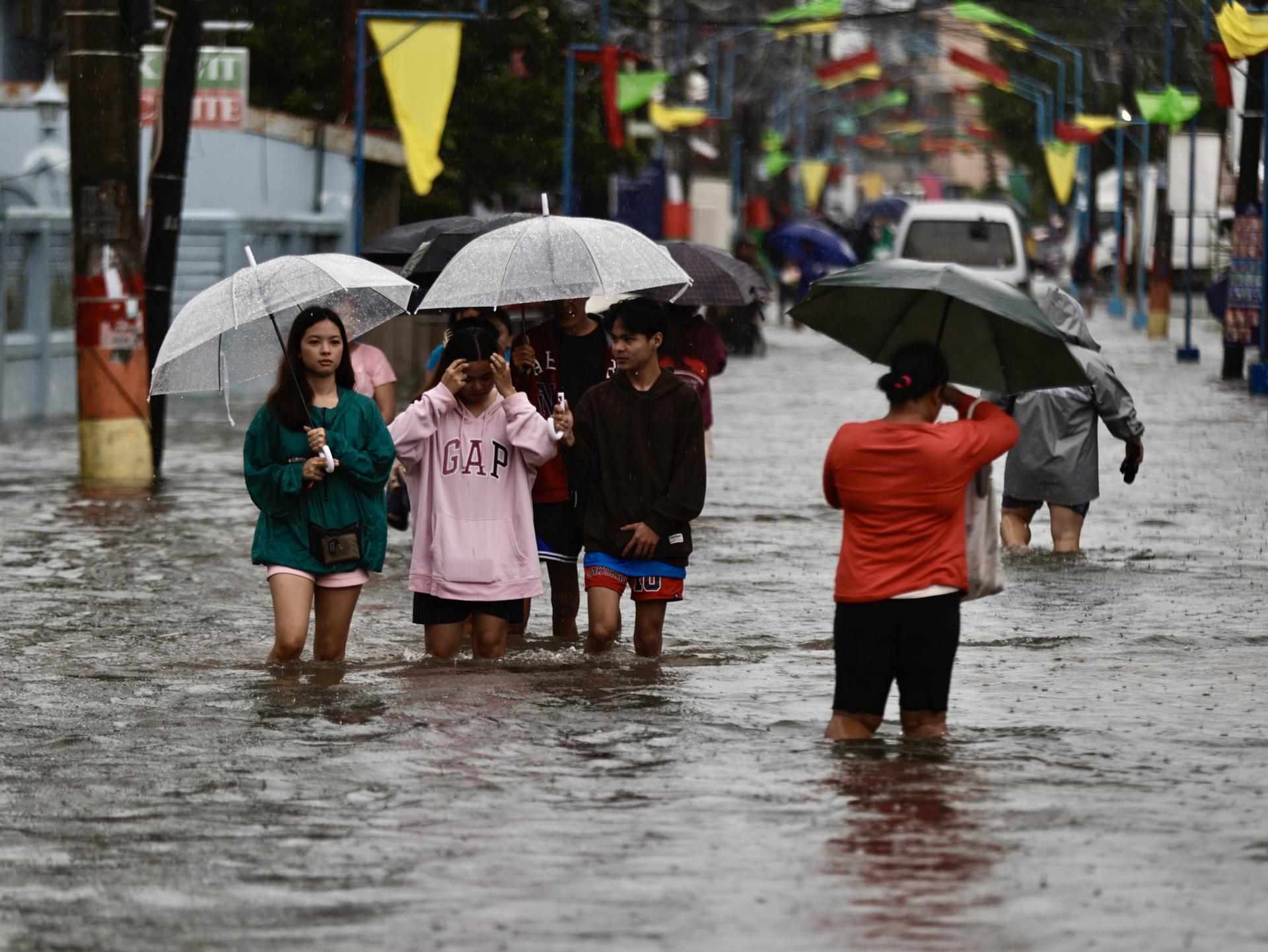 KAWIT (Philippines), 24/07/2025.- People wade through floodwater at the flood-hit town of Kawit, Cavite province, south of Manila, Philippines, 24 July 2025. The Philippines weather bureau projected typhoon Co-May to be 210 kilometers west of Pangasinan province in the northern Philippines, with winds of 120 kilometers per hour near its center. (Filipinas) EFE/EPA/FRANCIS R. MALASIG