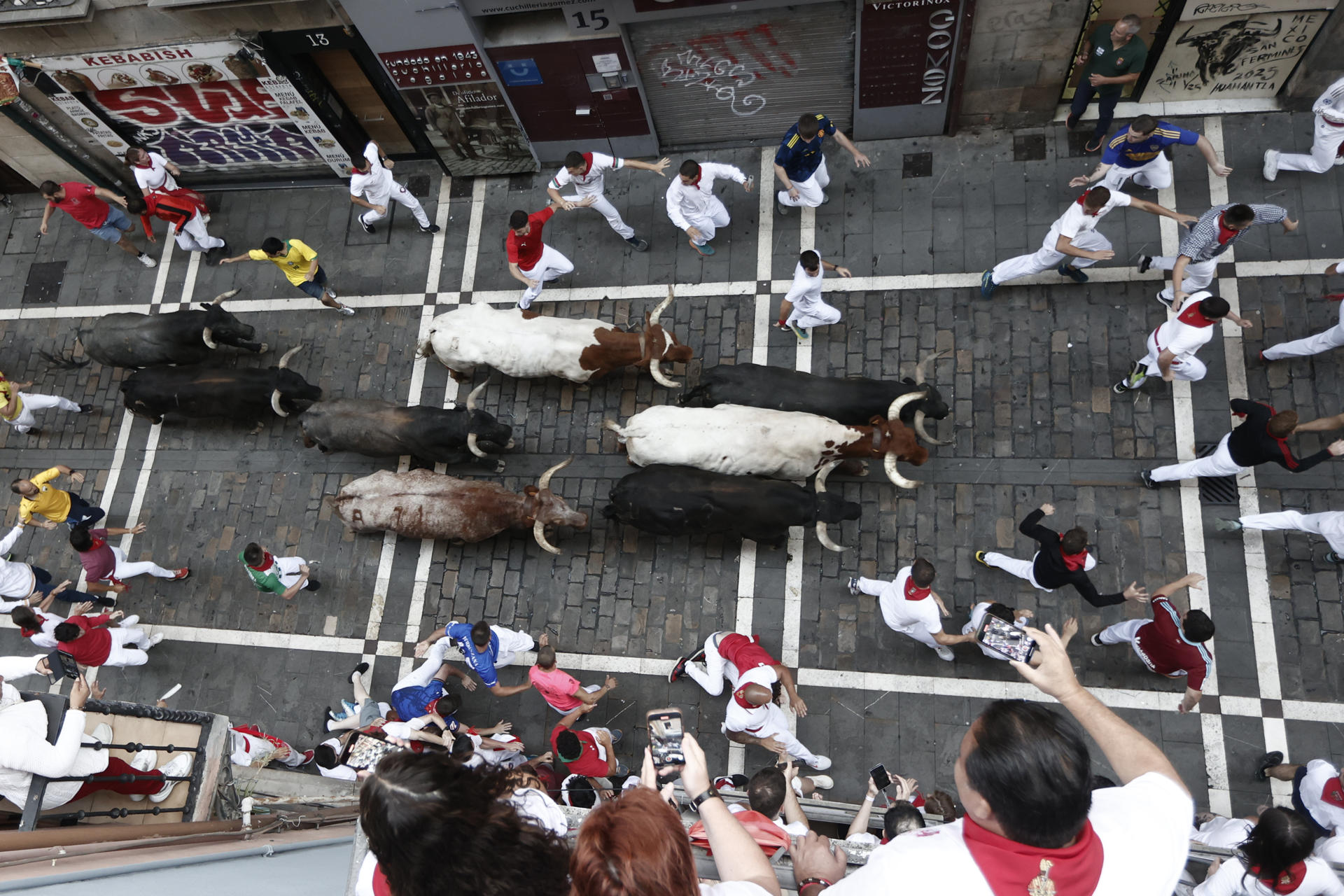 Los mozos son perseguidos por toros de la ganadería sevillana de Miura durante el octavo y último encierro de los Sanfermines este lunes. EFE/ Jesús Diges