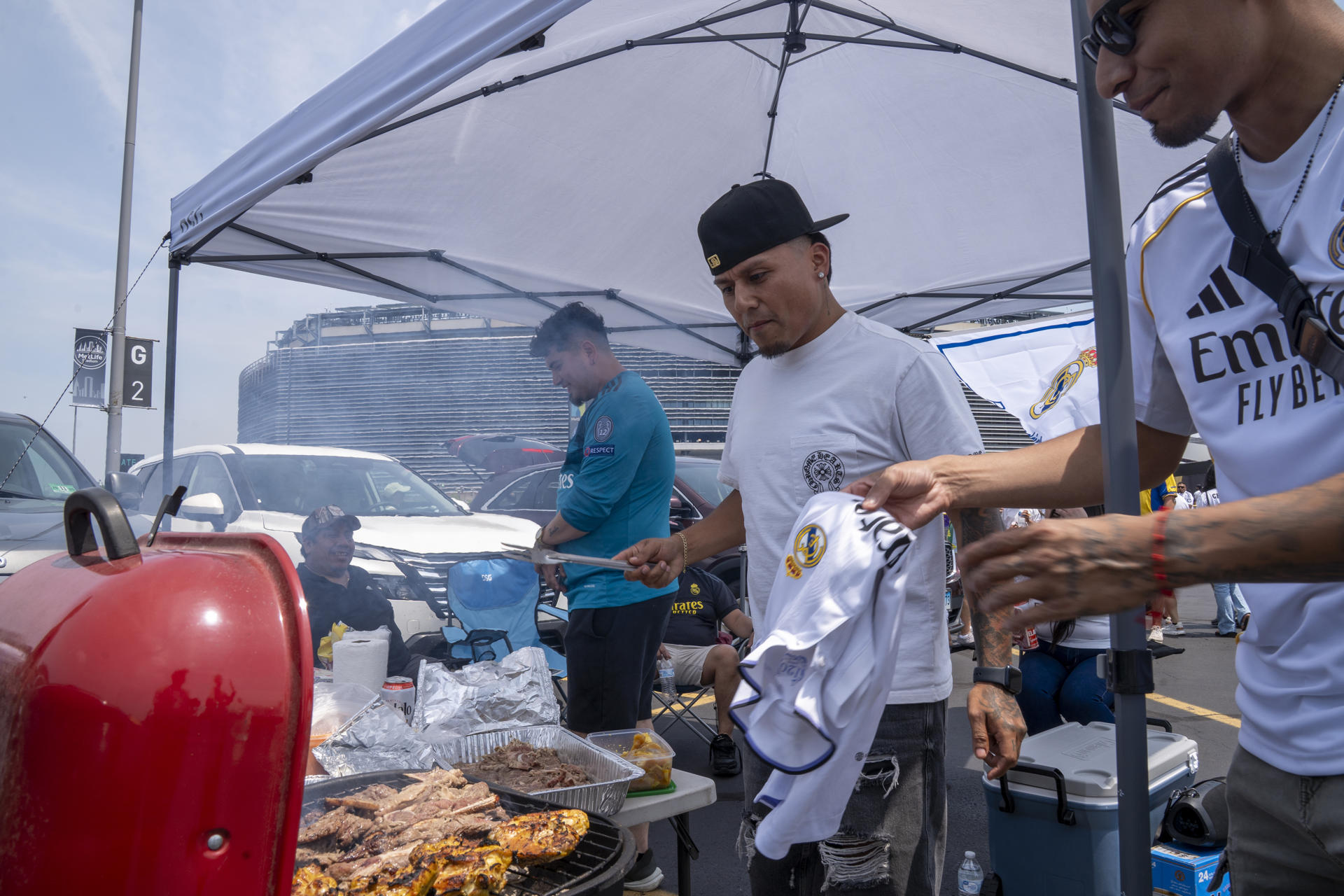 Aficionados del Real Madrid preparan alimentos antes del juego del Mundial de Clubes entre Real Madrid y Borussia Dortmund. EFE/Ángel Colmenares