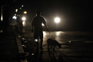 Una persona fue captada en la madrugada de este 1 de julio al pasear con su perro por una calle de La Habana, durante uno de los diarios apagones eléctricos en Cuba. EFE/Ernesto Mastrascusa