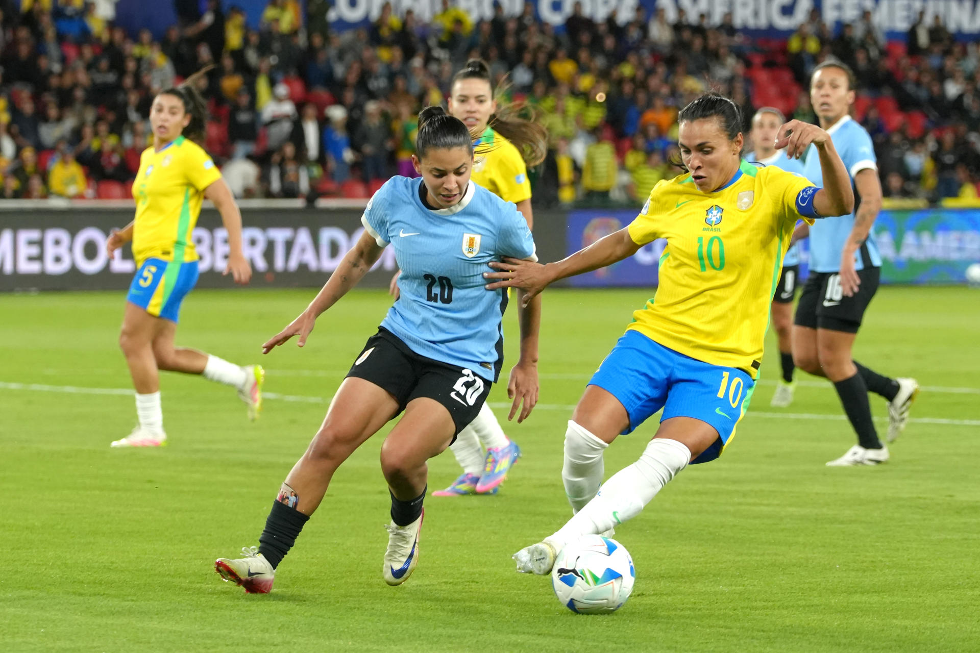 Marta (d), de Brasil, disputa el balón con Angela Gómez, de Uruguay, en la semifinal de la Copa América Femenina en el estadio Rodrigo Paz Delgado, en Quito (Ecuador). EFE/Vicente Costales