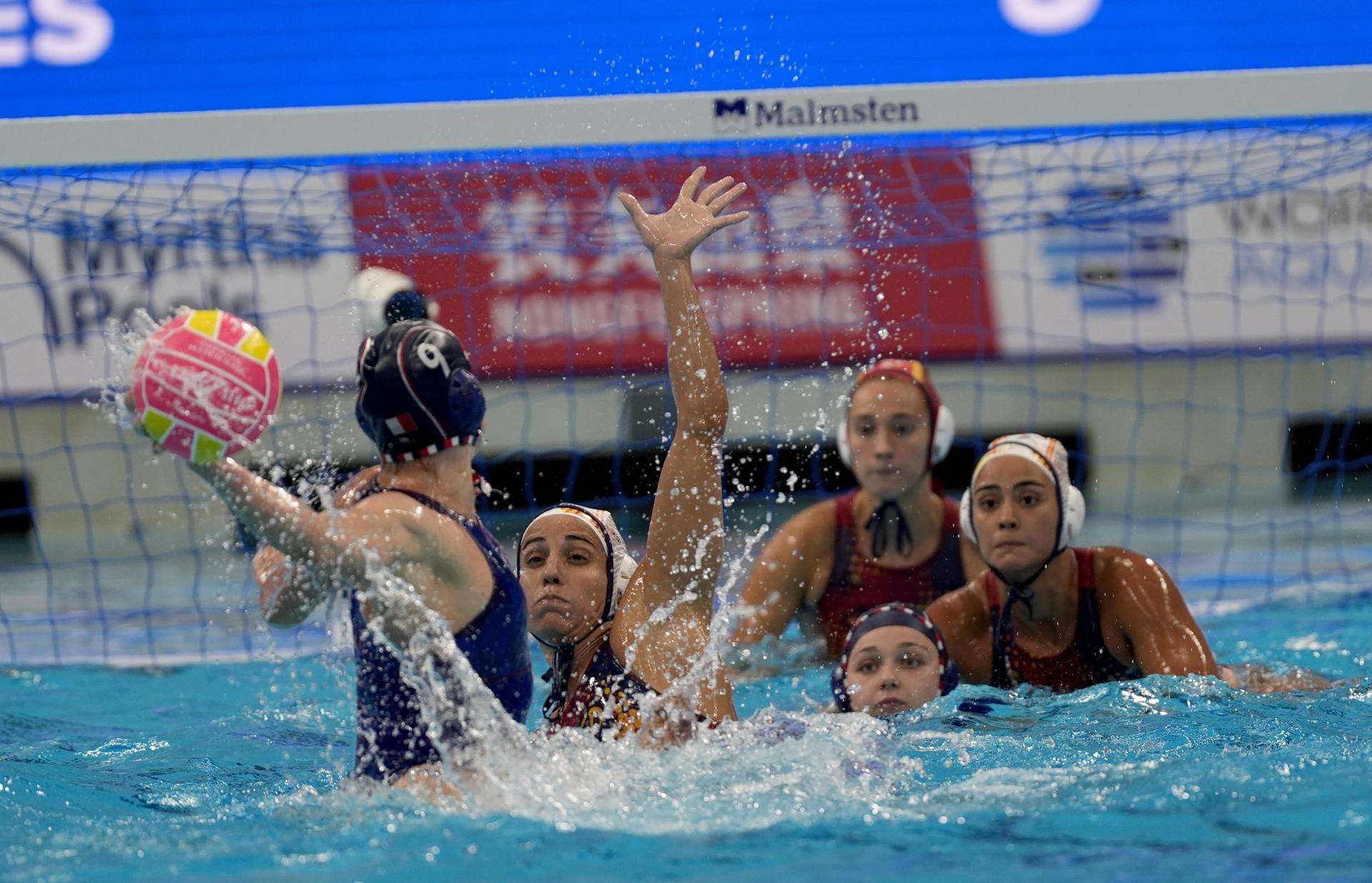 La jugadora francesa Vernoux Ema (i) en acción contra las jugadoras de España durante el partido de waterpolo femenino entre Francia y España en los Campeonatos Mundiales de Natación Singapur 2025. EFE/EPA/SIMON LIM