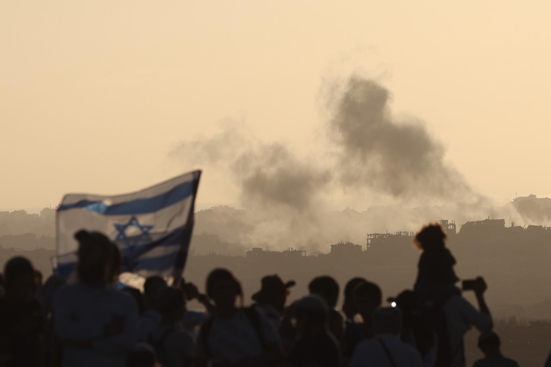 El humo se eleva desde Gaza después de un ataque aéreo israelí, mientras colonos israelíes radicales se manifiestan pidiendo el regreso de los asentamientos judíos en Gaza, en una zona cercana a la frontera con la Franja de Gaza, este miércoles.- EFE/ Abir Sultan