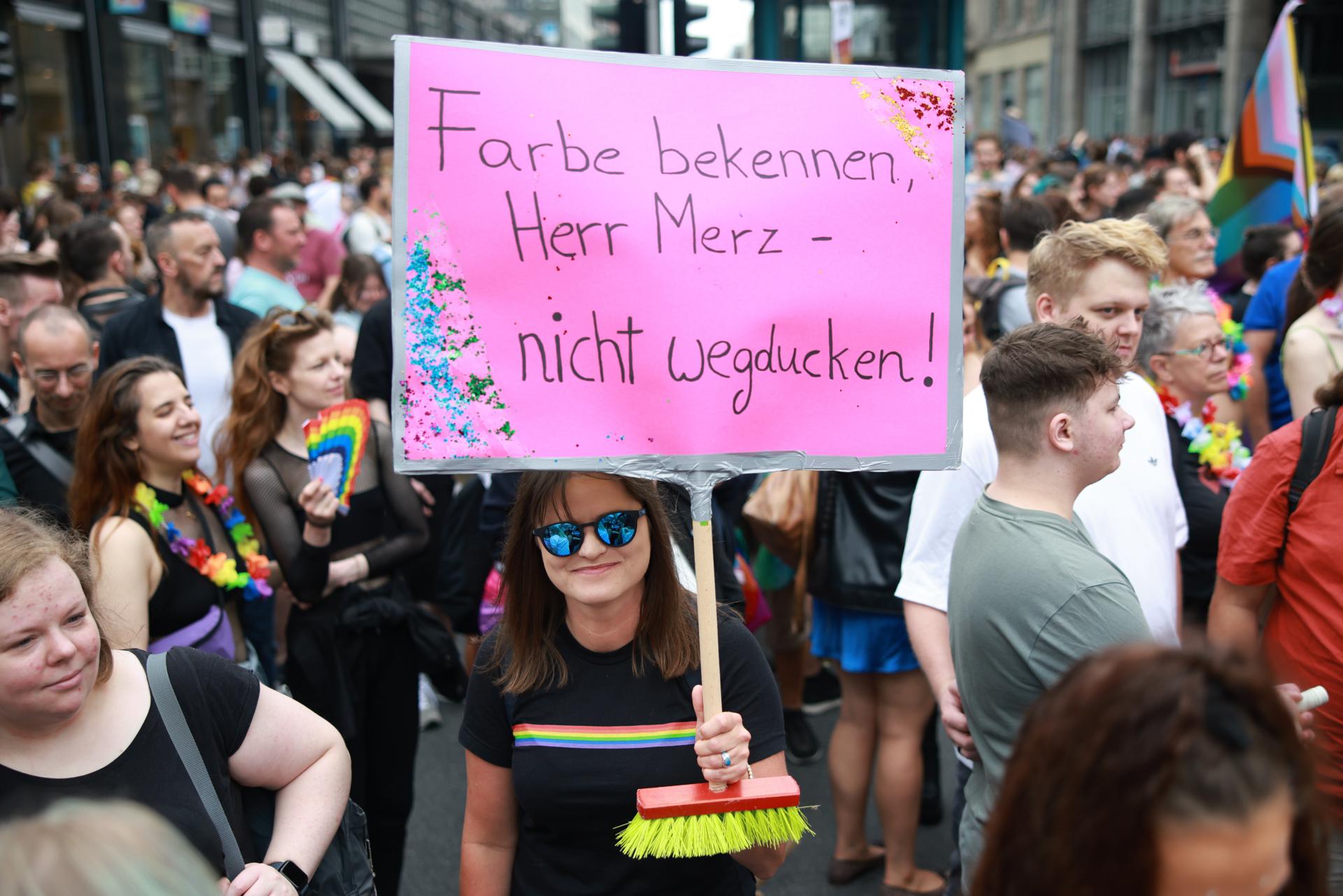 Una manifestante sostiene un cartel que dice: 'Hable claro, Sr. Merz, no se esconda' durante el 'CSD Berlín 2025', este sábado 26 de julio de 2025. EFE/EPA/CLEMENS BILAN