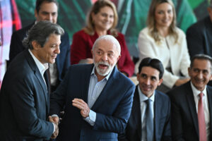 El presidente de Brasil, Luiz Inácio Lula da Silva (c), saluda al ministro de Hacienda, Fernando Haddad (i), durante la ceremonia de lanzamiento del Plan ''Safra'' 2025/2026 este martes, en el Palacio del Planalto en Brasilia (Brasil). EFE/Andre Borges