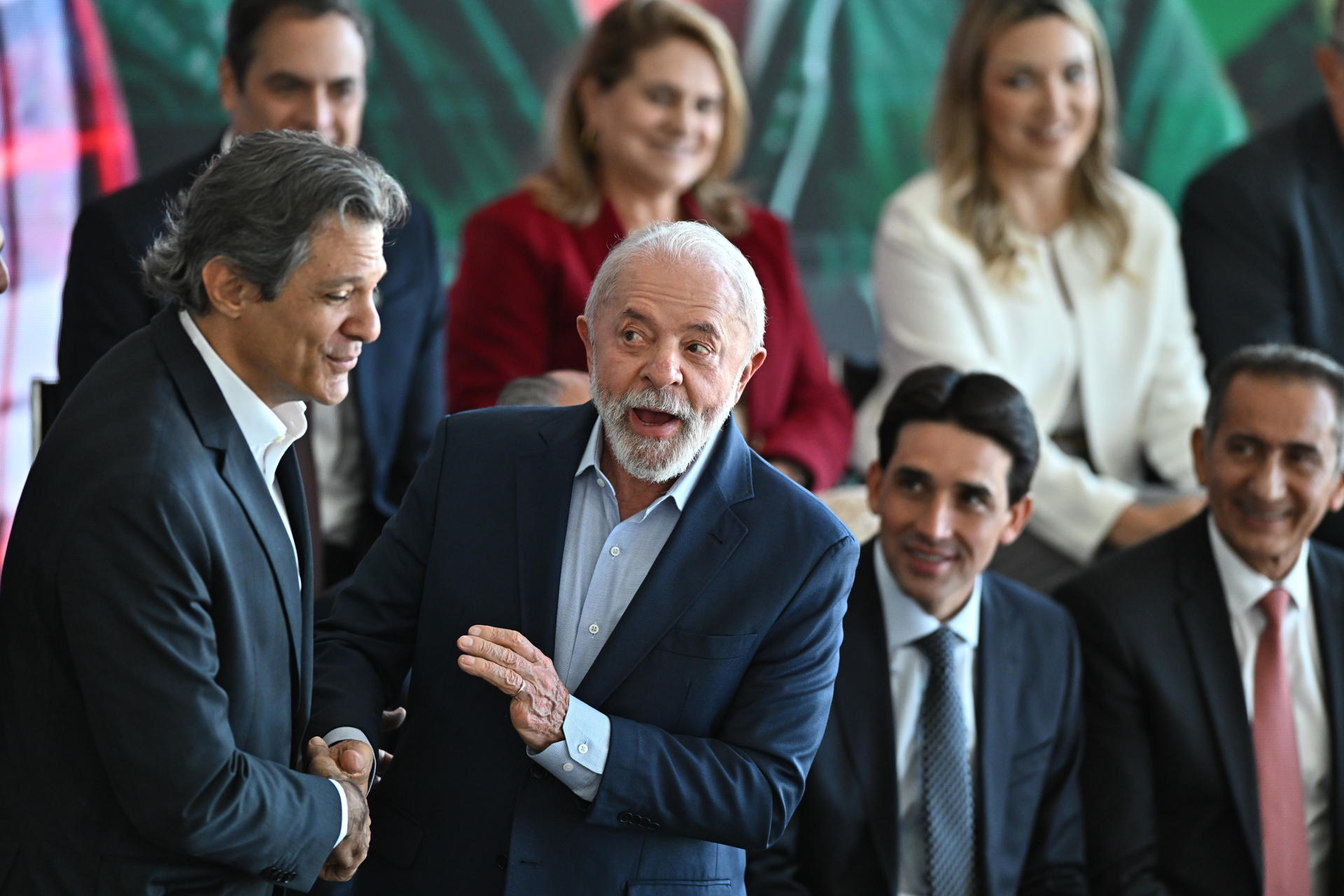 El presidente de Brasil, Luiz Inácio Lula da Silva (c), saluda al ministro de Hacienda, Fernando Haddad (i), durante la ceremonia de lanzamiento del Plan ''Safra'' 2025/2026 este martes, en el Palacio del Planalto en Brasilia (Brasil). EFE/Andre Borges