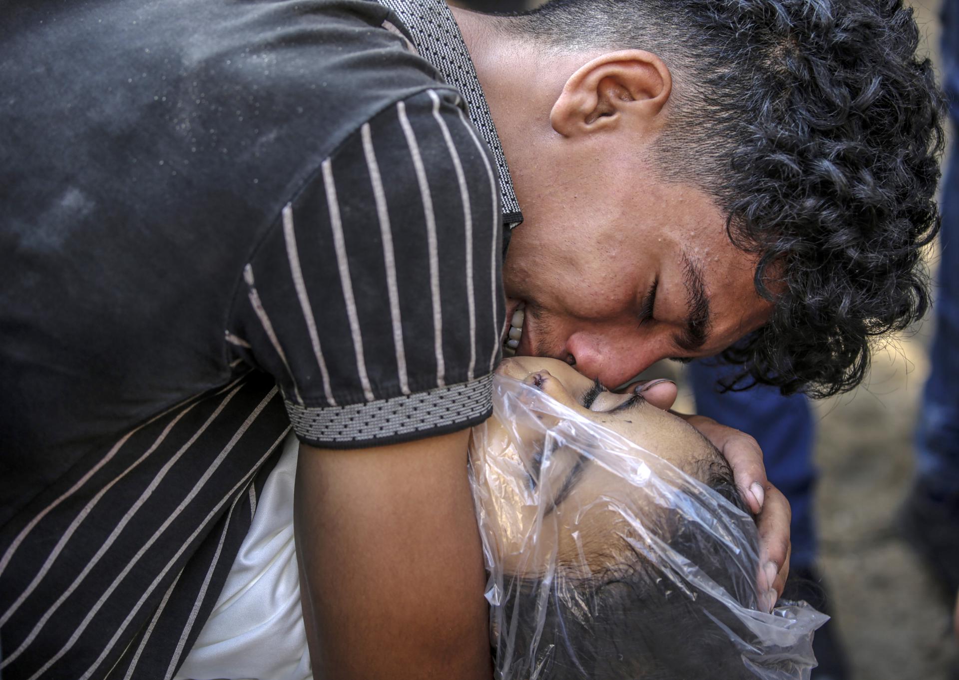 Un joven palestino llora abrazado al cuerpo sin vida de su hermano en el hospital de Al-Shifa, en Ciudad de Gaza, en una fotografía de archivo. EFE/ Mohammed Saber