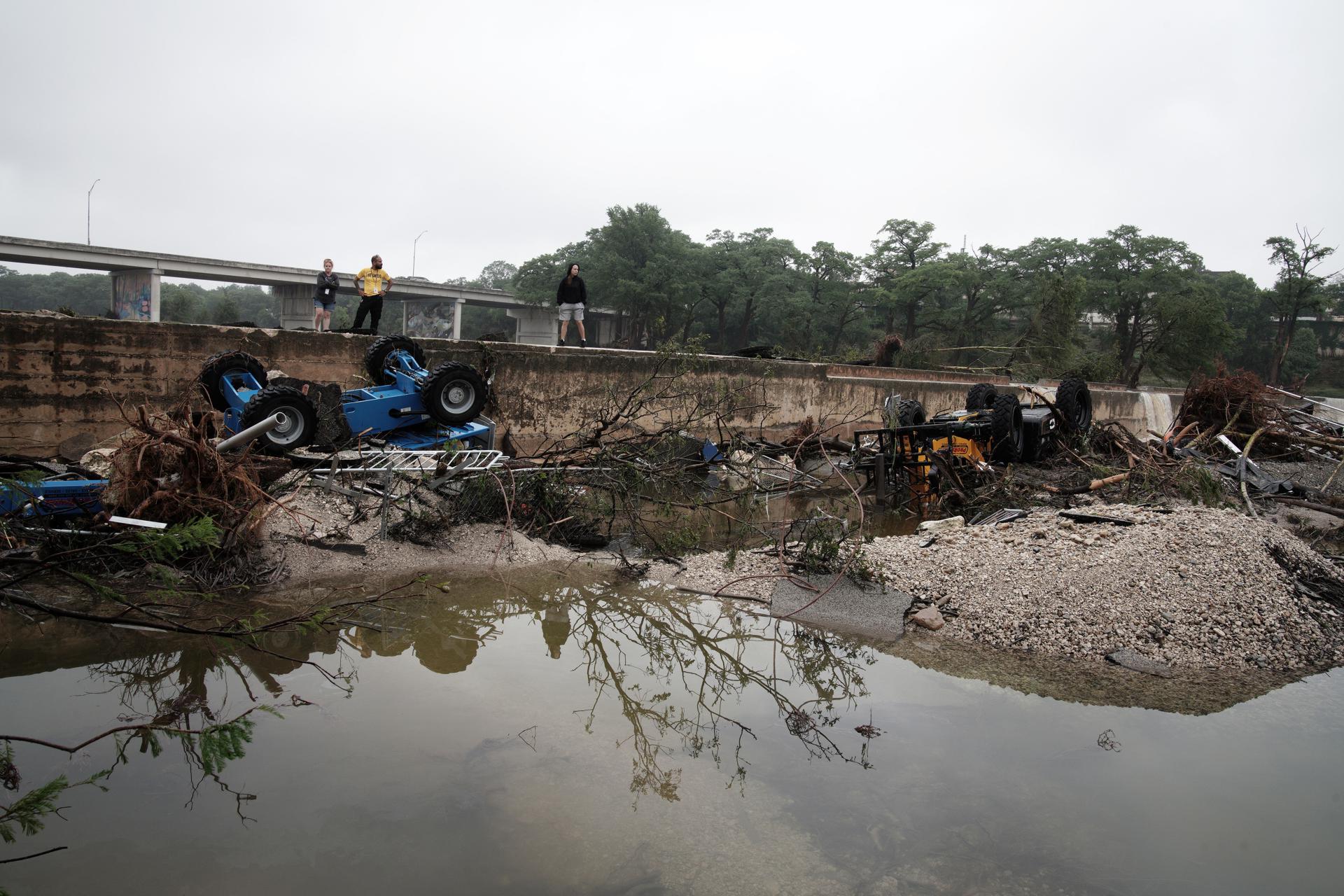 Un grupo de personas fue captado este sábado, 5 de julio, al observar los estragos que dejó la crecida del río Guadalupe en Kerrville (Texas, EE.UU.). EFE/Dustin Safranek