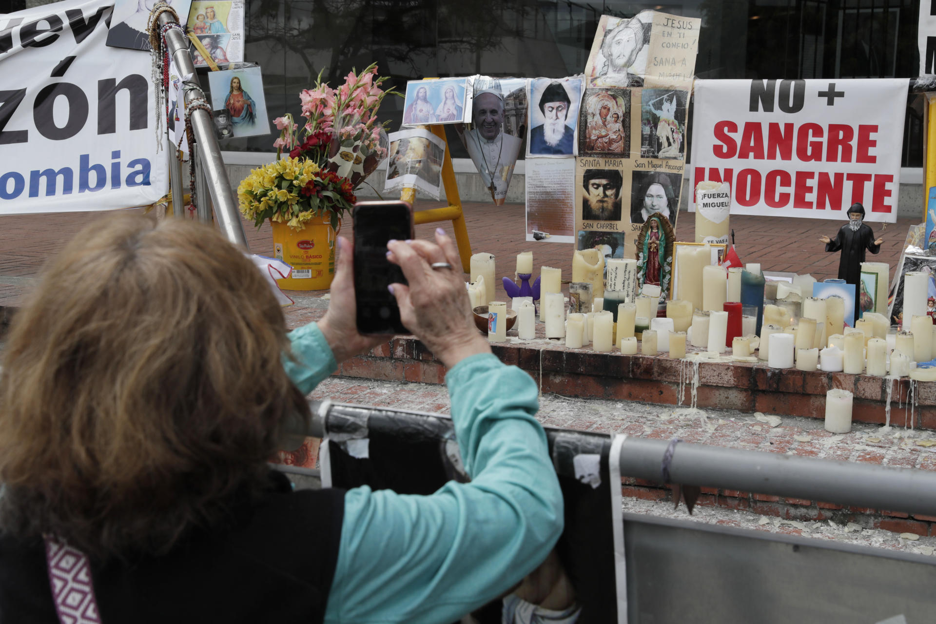 Personas oran en un altar improvisado frente a la Fundación Santa Fe, lugar donde permanece hospitalizado el senador colombiano Miguel Uribe Turbay, este domingo en Bogotá (Colombia). EFE/ Carlos Ortega