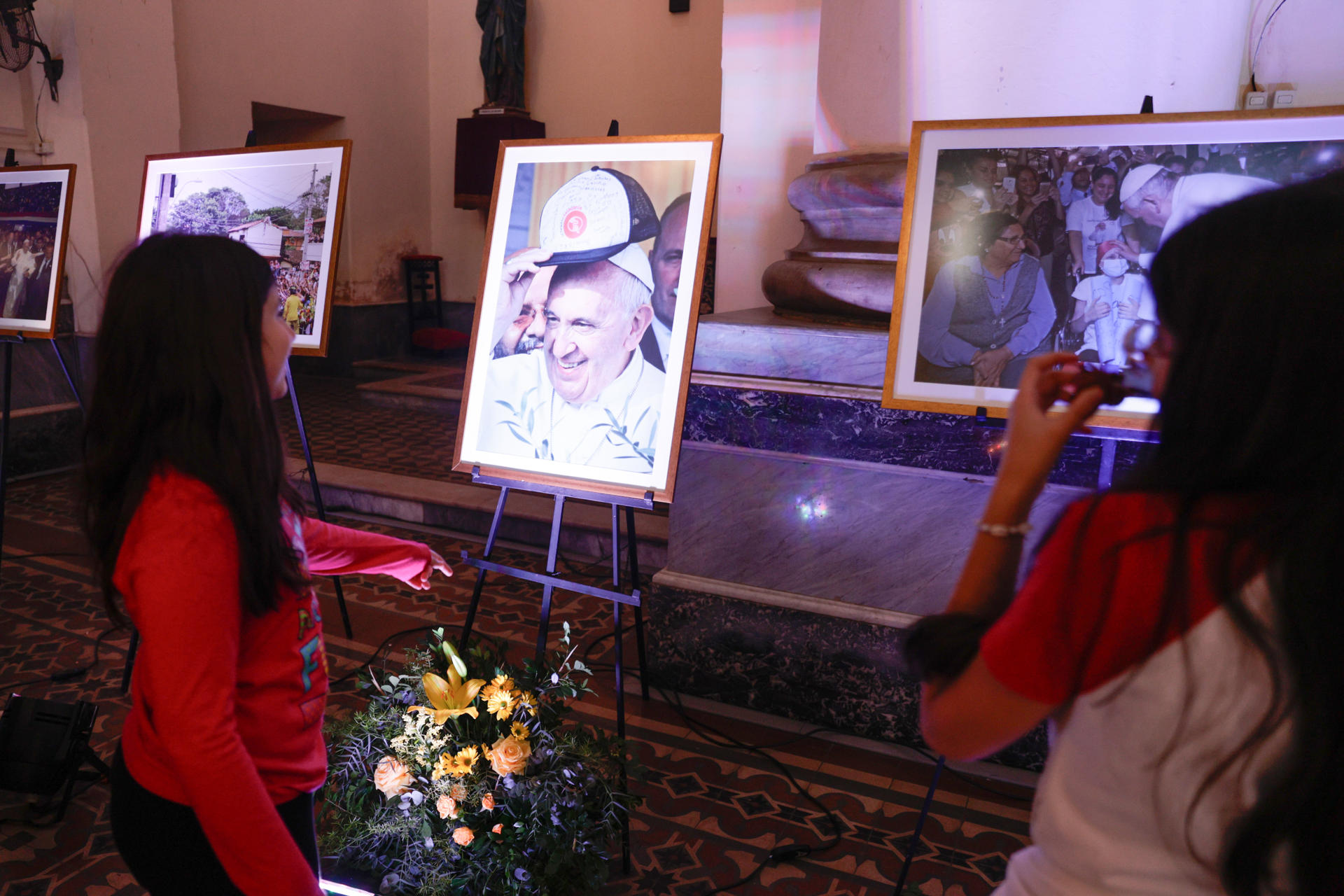 Personas observan una exposición religiosa con motivo del décimo aniversario de la visita del papa Francisco a Paraguay este sábado, en el templo de La Encarnación, en Asunción (Paraguay). EFE/ Juan Pablo Pino