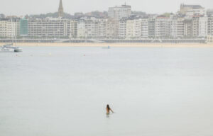Una mujer se baña a primera hora de este lunes en la playa de Ondarreta de San Sebastián. EFE/Javier Etxezarreta