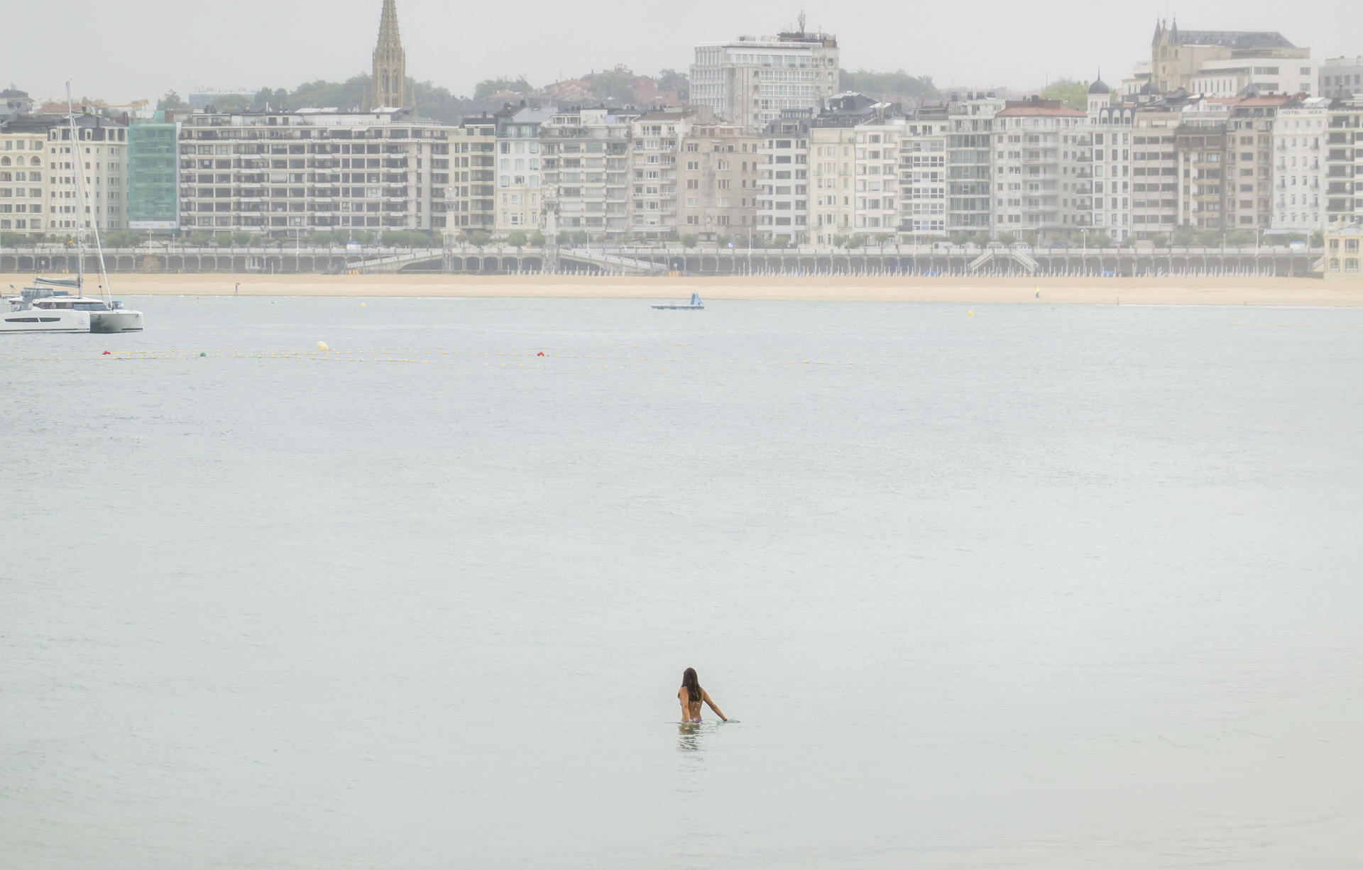 Una mujer se baña a primera hora de este lunes en la playa de Ondarreta de San Sebastián. EFE/Javier Etxezarreta