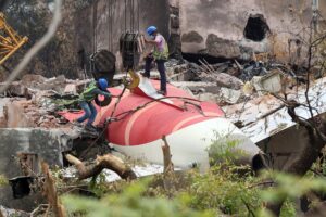 Fotografía del 14 de junio de 2025 que muestra a trabajadores indios que retiran los restos del avión de Air India con una grúa del lugar del accidente, cerca del aeropuerto de Ahmedabad (India). EFE/EPA/RAJAT GUPTA