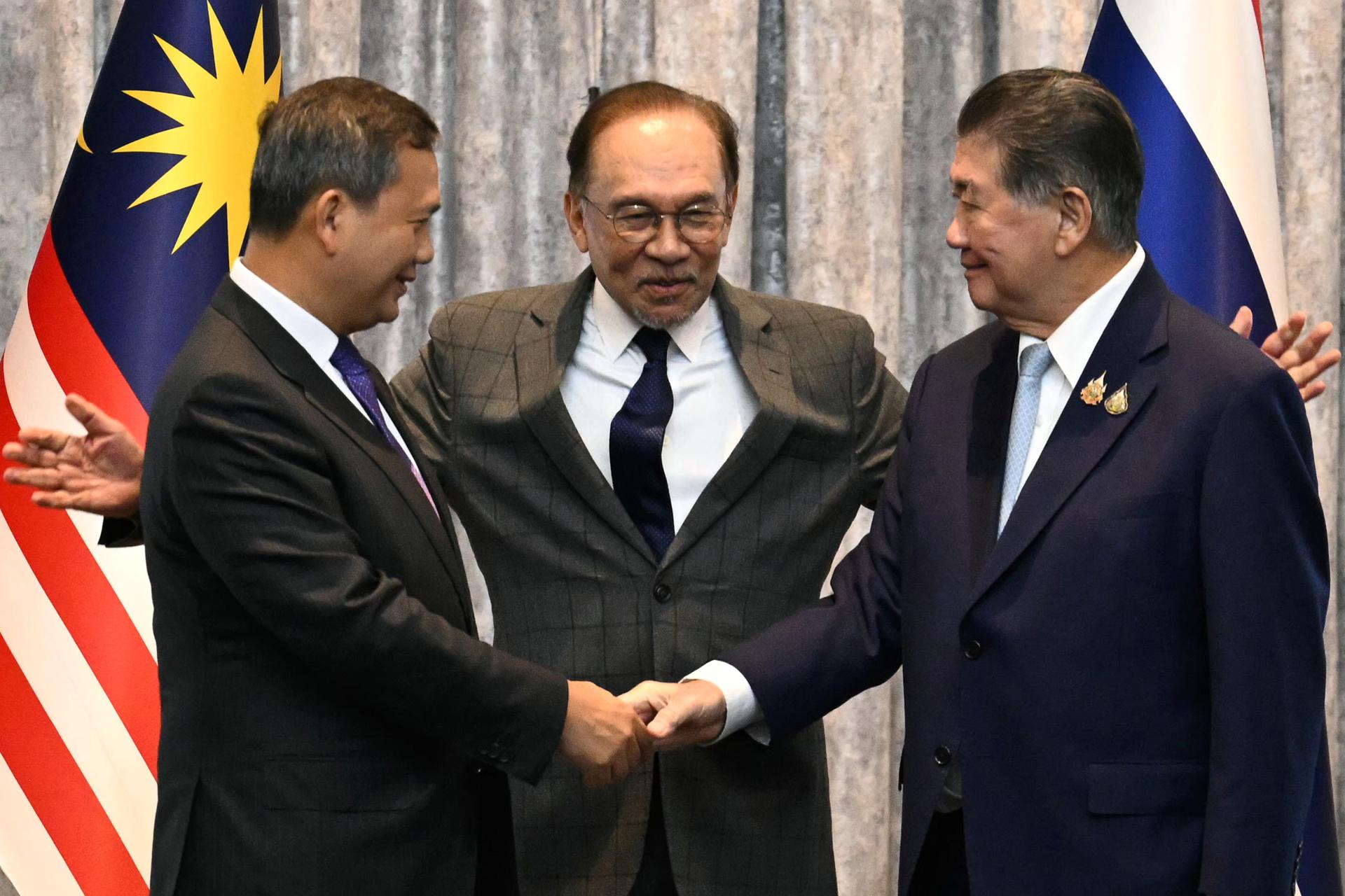 PUTRAJAYA (Malaysia), 28/07/2025.- Cambodia's Prime Minister Hun Manet (L) and Thailand's acting Prime Minister Phumtham Wechayachai (R) shake hands as Malaysia's Prime Minister Anwar Ibrahim (C) puts his arms around them following a press conference after talks on a possible ceasefire between Thailand and Cambodia in Putrajaya, Malaysia, 28 July 2025. Thailand and Cambodia's leaders are due to meet for peace talks on 28 July, as a festering territorial dispute along their shared frontier dragged into a fifth day of open combat. (Camboya, Malasia, Tailandia) EFE/EPA/MOHD RASFAN / POOL
