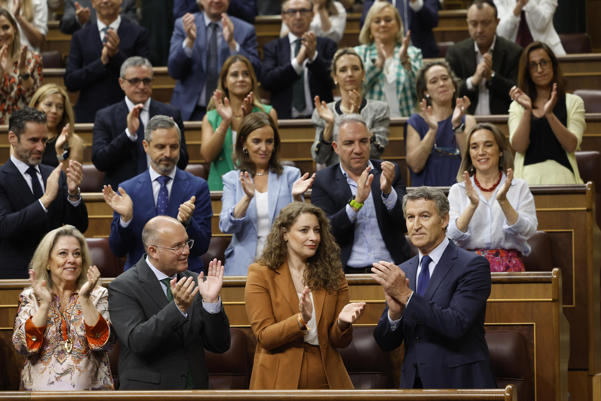 El líder del Partido Popular, Alberto Núñez Feijóo (d) es aplaudido por la bancada popular tras su intervención en el pleno del Congreso de los Diputados este miércoles. EFE/Mariscal
