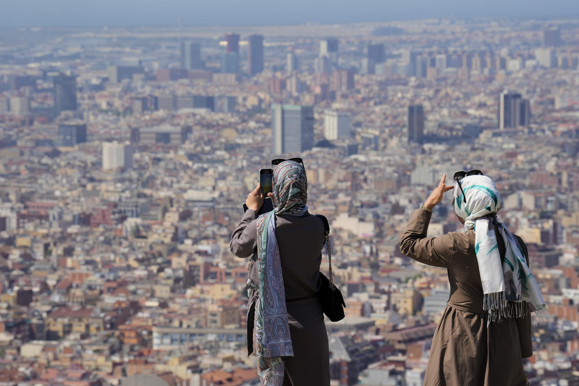 Turistas en el Turó de la Rovira de Barcelona este mes de junio en medio de la ola de calor. EFE/Alejandro García