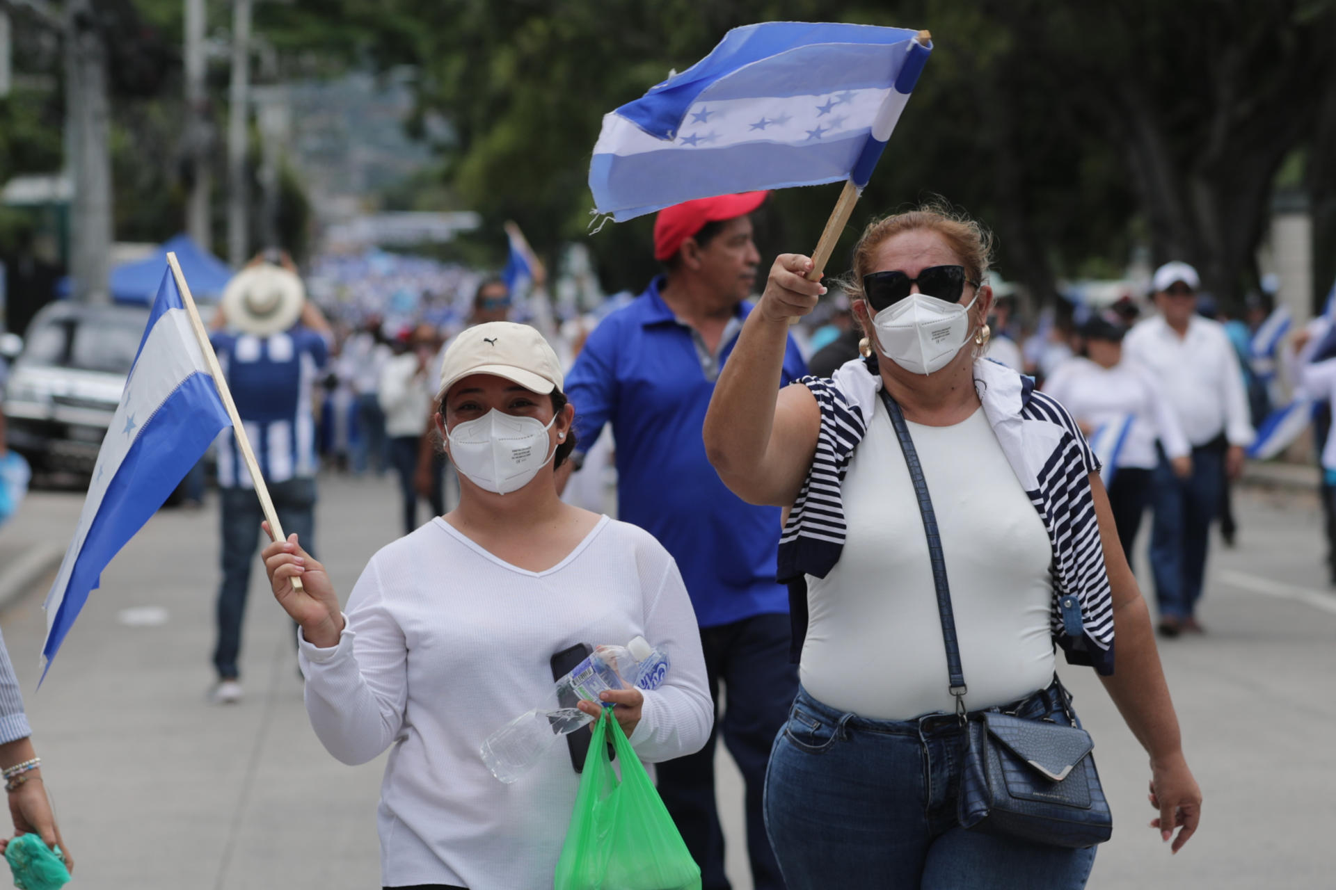 Personas sostienen banderas durante una manifestación convocada por el candidato presidencial por el Partido Nacional, Nasry Asfura, este domingo en Tegucigalpa (Honduras). EFE/ Gustavo Amador