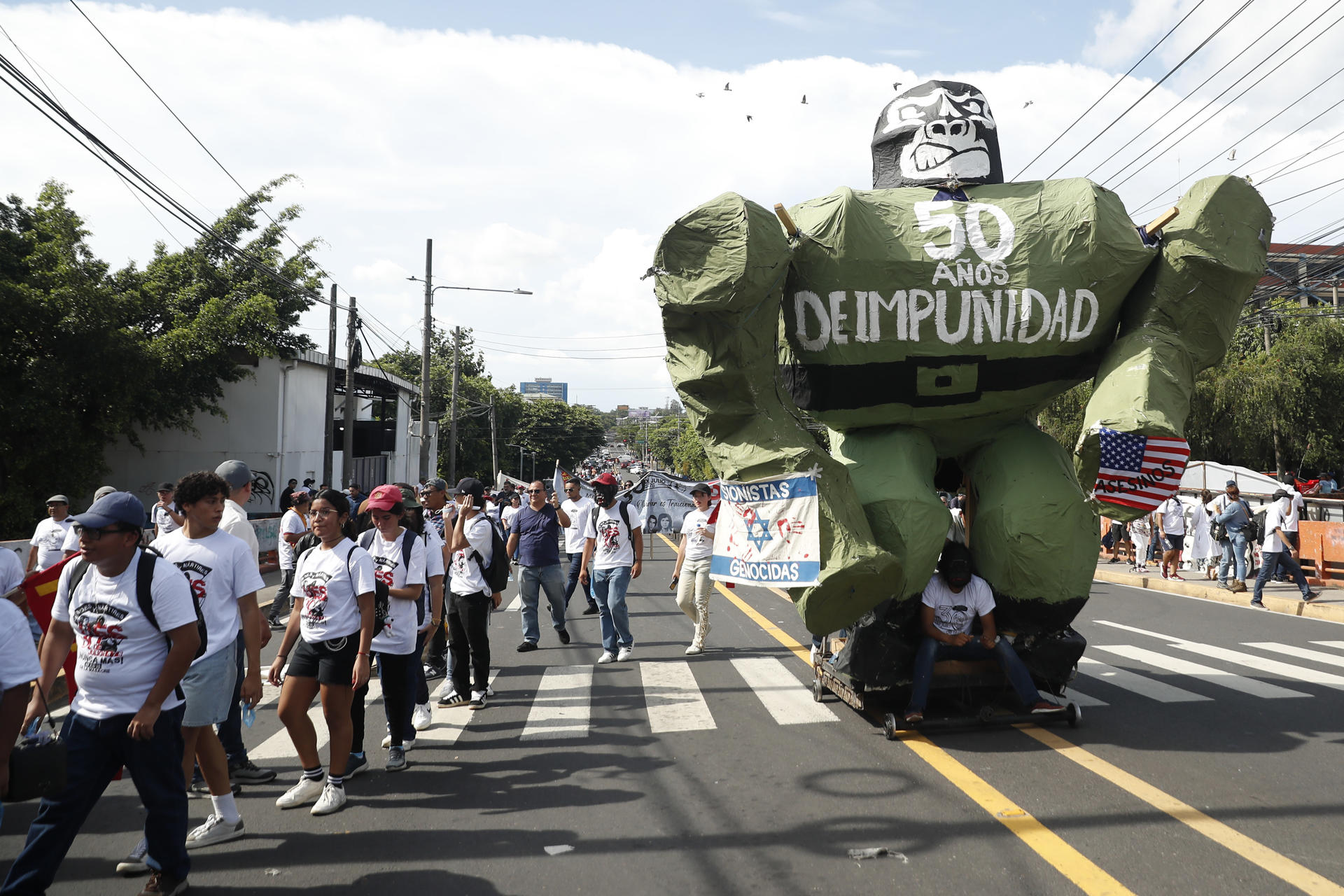 Estudiantes y docentes de la Universidad de El Salvador (UES) participan en una marcha en conmemoración del 50 aniversario de la masacre de universitarios, este miércoles en San Salvador (El Salvador). EFE/Rodrigo Sura