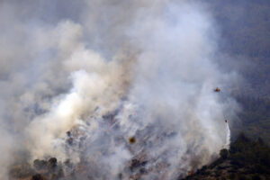 Un helicóptero trabaja en la tareas de extinción del incendio forestal de alta intensidad de Paüls (Tarragona). EFE/ Quique García