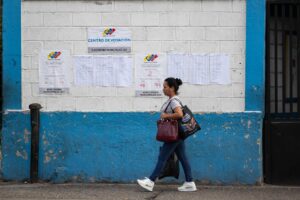 Una mujer camina frente a un centro de votación durante las elecciones municipales y concejales este domingo, en Caracas (Venezuela). EFE/ Ronald Peña R