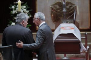 El hijo de la ex primera dama de Colombia Nydia Quintero, Julio Cesar Turbay Quintero (i), es abrazado por el ministro de Salud de Colombia, Guillermo Alfonso Jaramillo, durante una ceremonia este lunes, en el Capitolio Nacional en Bogotá (Colombia). EFE/ Carlos Ortega