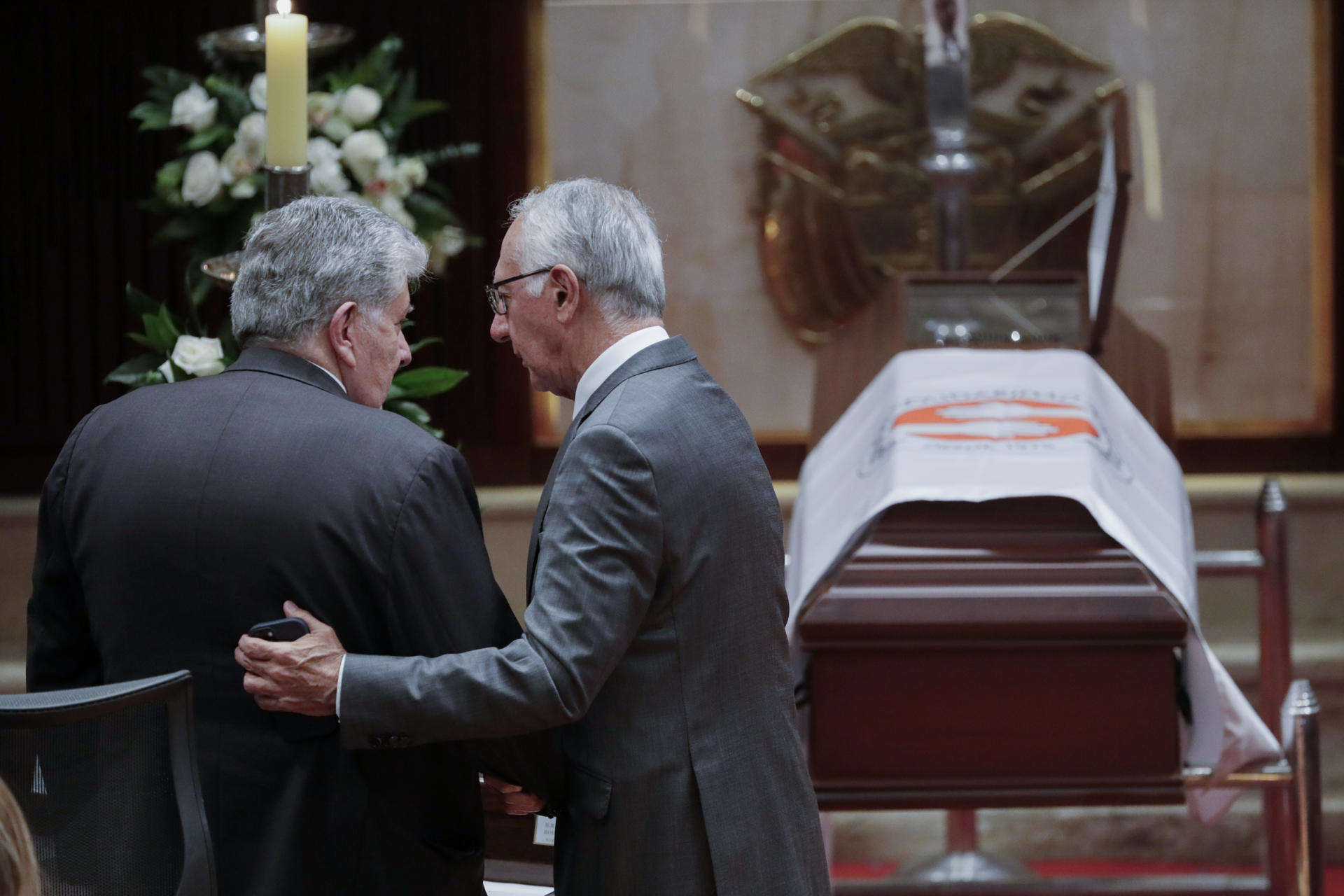 El hijo de la ex primera dama de Colombia Nydia Quintero, Julio Cesar Turbay Quintero (i), es abrazado por el ministro de Salud de Colombia, Guillermo Alfonso Jaramillo, durante una ceremonia este lunes, en el Capitolio Nacional en Bogotá (Colombia). EFE/ Carlos Ortega