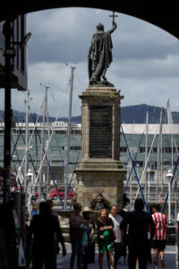 Varios turistas pasan junto a la estatua del Rey Pelayo al fondo, este lunes. EFE/Paco Paredes