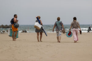 Varias personas se dirigen la playa de la Malvarrosa durante este martes. EFE/Manuel Bruque