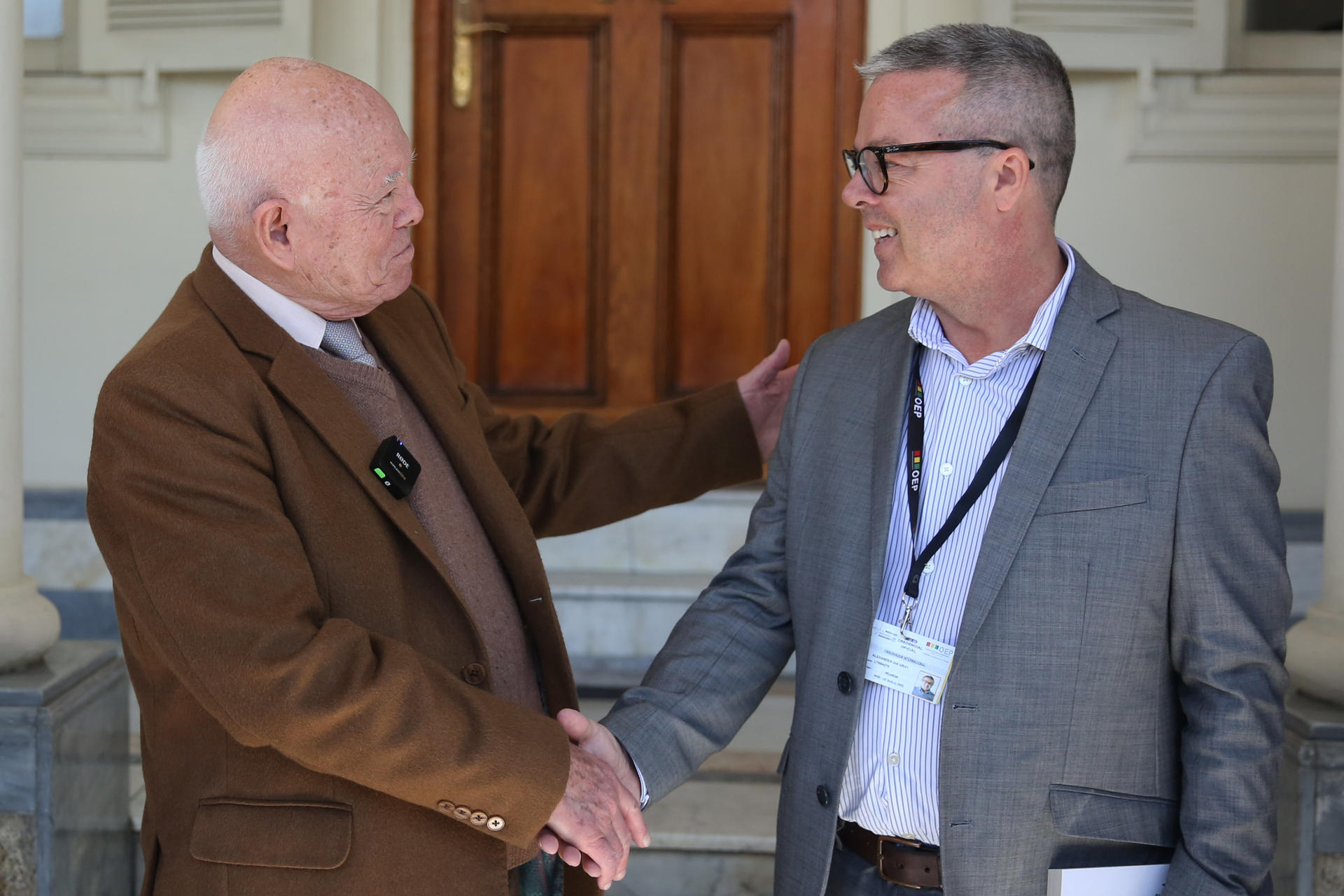 El presidente del Tribunal Supremo Electoral (TSE), Oscar Hassenteufel (i), saluda al jefe adjunto de la misión de observación electoral de la Unión Europea, Alexander Ian Gray, en las oficinas del TSE este viernes, en La Paz (Bolivia). EFE/ Luis Gandarillas
