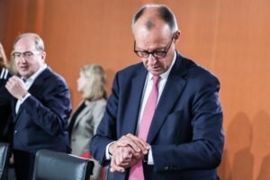Friedrich Merz (derecha) mira su reloj mientras asiste a la reunión del gabinete federal en la Cancillería en Berlín, Alemania, el 23 de julio de 2025. (Alemania) EFE/EPA/FILIP SINGER