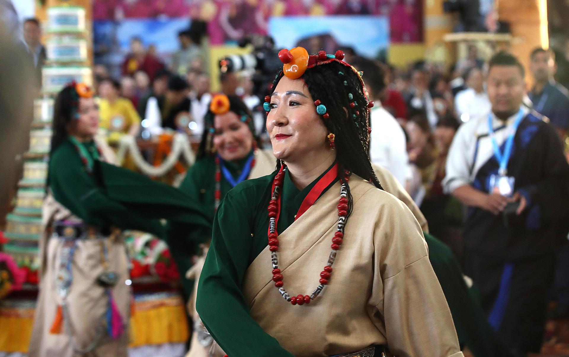 Mujeres tibetanas vestidas con un traje tradicional interpretan una danza durante la ceremonia por los 90 años del dalái lama. EFE/EPA/HARISH TYAGI
