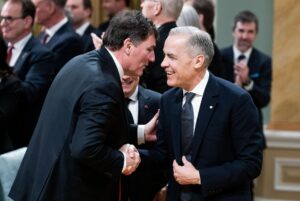 Fotografía de archivo del primer ministro canadiense, Mark Carney (d), al escuchar a su ministro de Asuntos Intergubernamentales, Dominic LeBlanc, durante un acto público, en Ottawa (Canadá). EFE/Spencer Colby