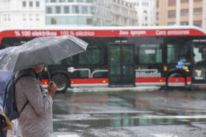 Una persona se protege del agua con paraguas este lunes en Bilbao. EFE/Luis Tejido