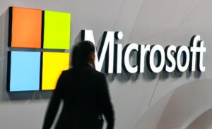 Fotografía de archivo de una mujer junto al logo de Microsoft. EFE/HANNIBAL HANSCHKE