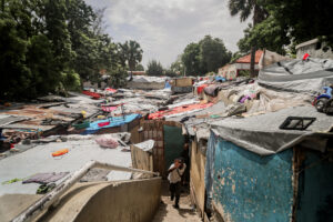 Un hombre camina en el campamento de refugiados Camp Mormón, donde cientos de familias han encontrando protección tras abandonar sus hogares por la violencia de las pandillas, en Puerto Príncipe (Haití). EFE/ Mentor David Lorens