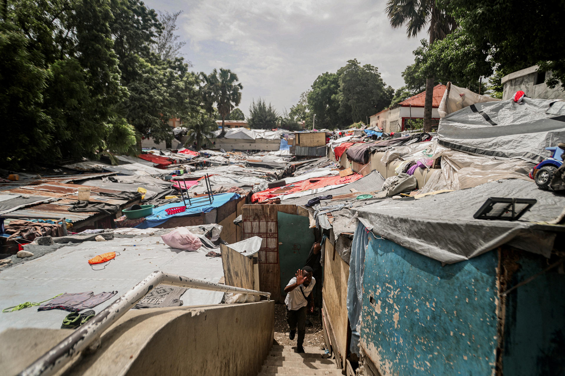 Un hombre camina en el campamento de refugiados Camp Mormón, donde cientos de familias han encontrando protección tras abandonar sus hogares por la violencia de las pandillas, en Puerto Príncipe (Haití). EFE/ Mentor David Lorens