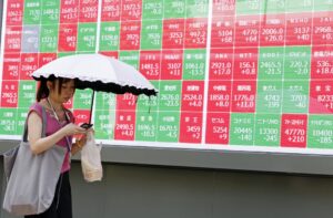 TOKIO (Japón), 08/07/2025.- Un transeúnte pasa junto a un panel indicador de la Bolsa en Tokio el 8 de julio de 2025, después de que el presidente estadounidense, Donald Trump, enviara una carta al país asiático que especifica la imposición de un arancel del 25 % a las importaciones procedentes de Japón a partir del 1 de agosto de 2025. EFE/EPA/FRANCK ROBICHON