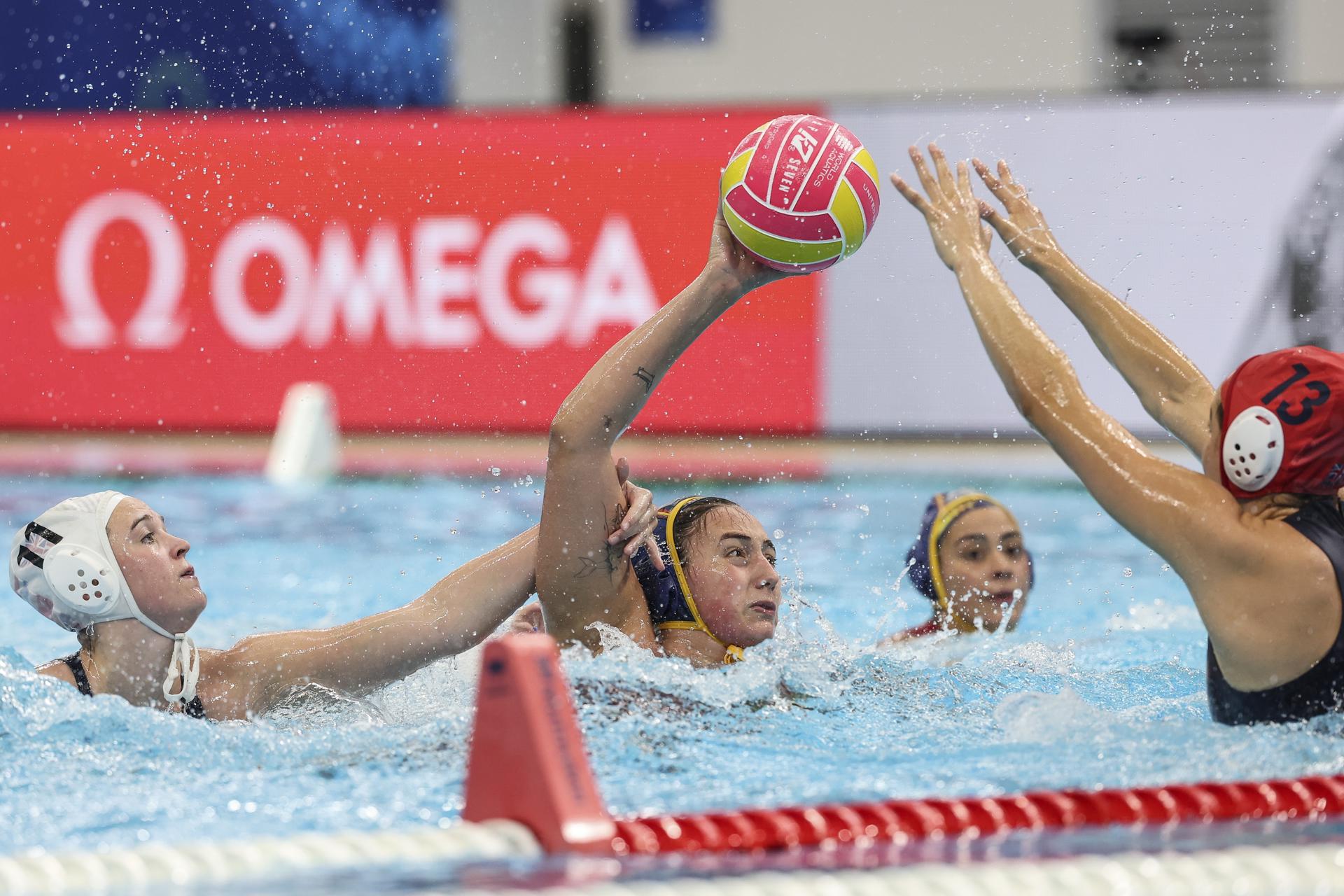 La española Paula Camus de España (C) en acción contra la inglesa Lucy Blenkinship (i) y la portera Cassidy Ball (d) durante el partido preliminar de waterpolo femenino entre Gran Bretaña y España en los Campeonatos Mundiales de Natación Singapur 2025. EFE/EPA/HOW HWEE YOUNG