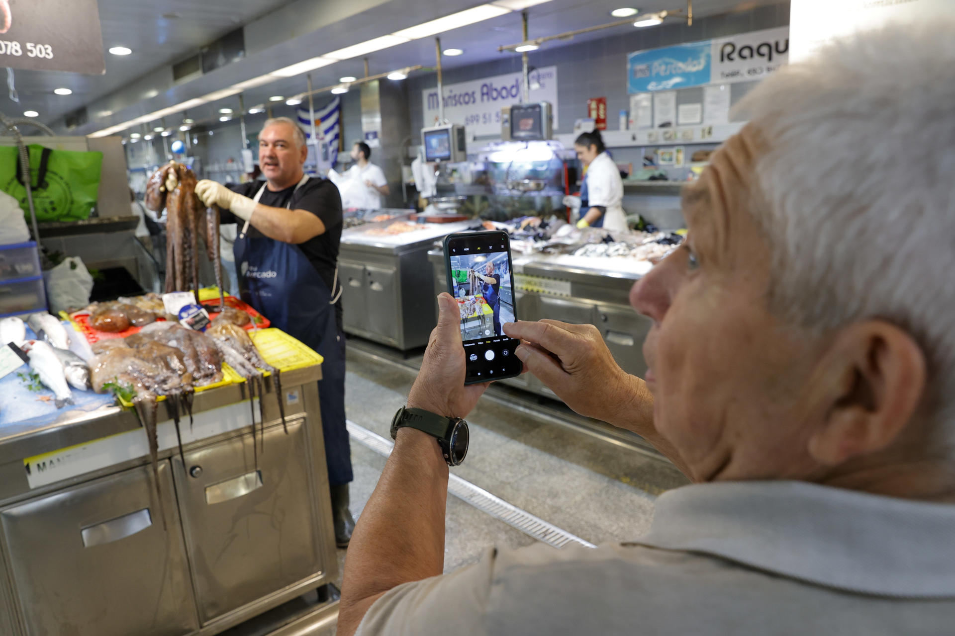 Un hombre saca fotos de un puesto con pulpo en el mercado de la plaza de Lugo, en A Coruña este viernes. El pulpo vive su mejor arranque de campaña en años en Galicia después de tres meses de parón, con capturas abundantes y de buena calidad que animan a pescadores y pescaderos y contrastan con el regreso moderado de la nécora tras seis meses de veda. EFE/Cabalar