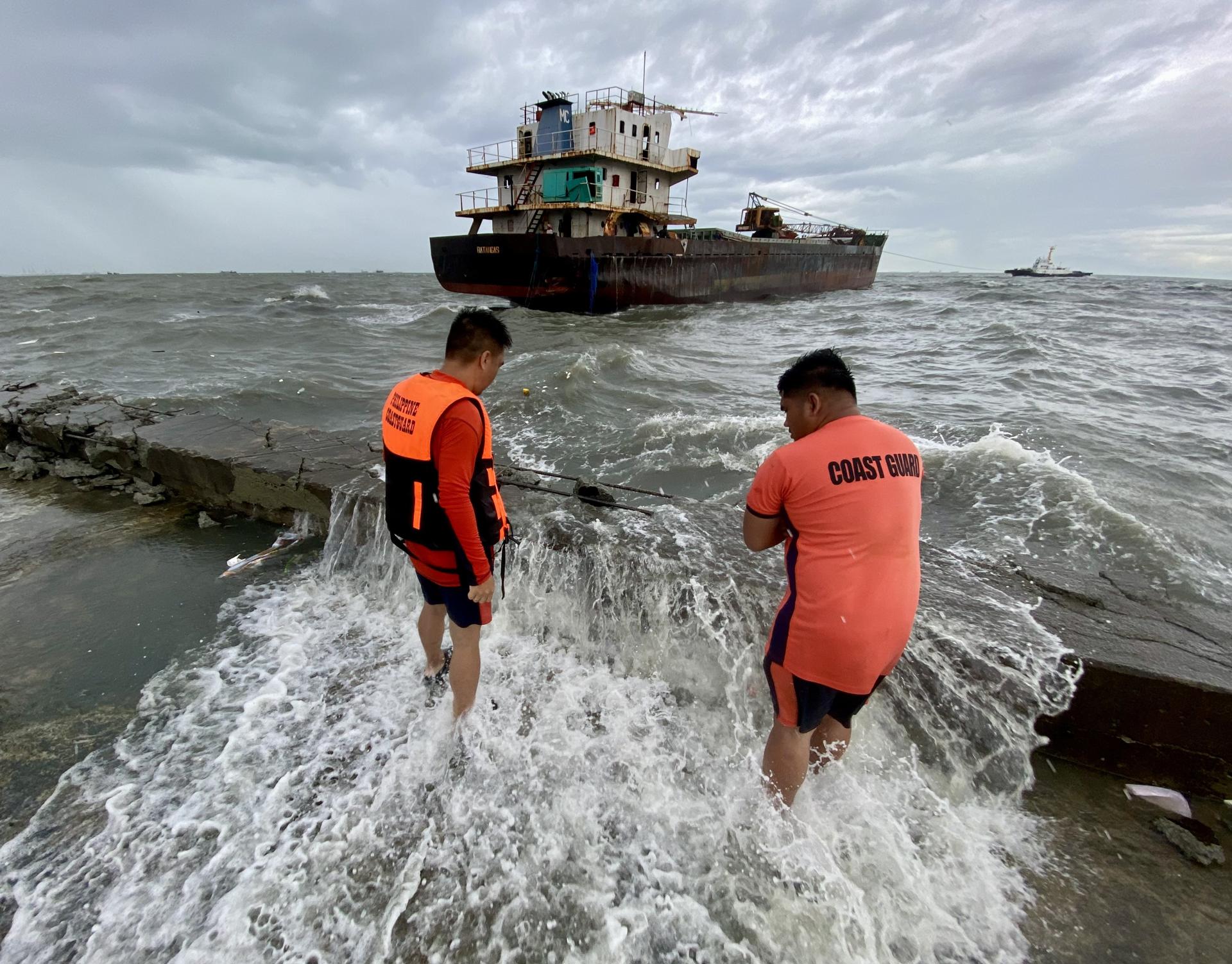 NAVOTAS CITY (Philippines), 25/07/2025.- Filipino coastguard personnel view a run-aground cargo ship in Navotas city, Metro Manila, Philippines, 25 July 2025. The Philippine National Disaster Risk Reduction and Management Council (NDRRMC) reported on 25 July that the death toll from the combined effects of over a week of storms was recorded at 25 and more than a million families are affected as Tropical Storm Co-May battered the northern part of main Philippine island, Luzon. (tormenta, Filipinas) EFE/EPA/FRANCIS R. MALASIG